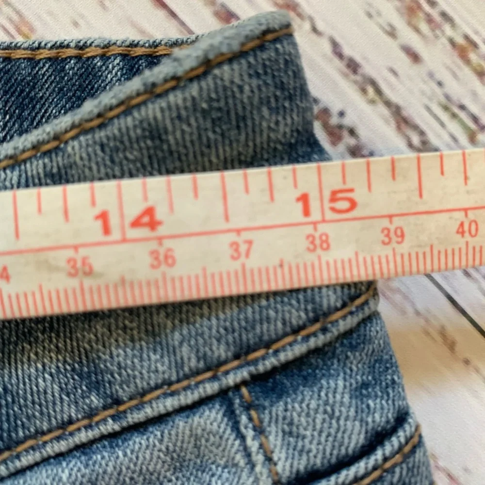 Level 99 jeans. Gold/silver design on bottom. Mid rise. Size 27.